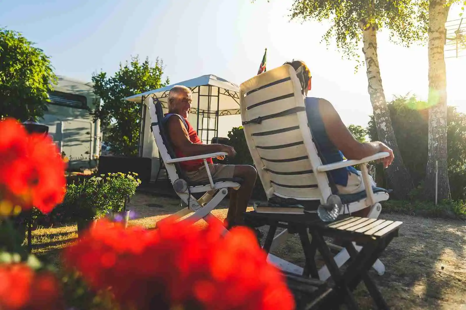 En grupp utemöbler under skugga på Haga Park Camping & Stugor där besökare kan koppla av och njuta av sommaren.