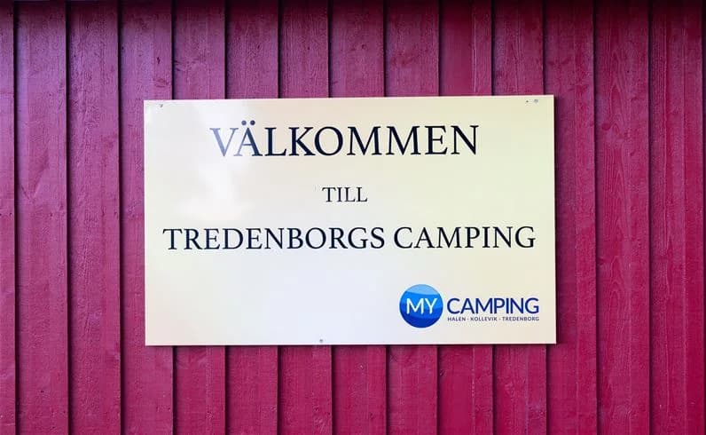 Bild av en campingplats vid My Camping Tredenborg. Det finns tält och trädgårdsbyggnader på området, samt rekreationsutrymmen för besökare.