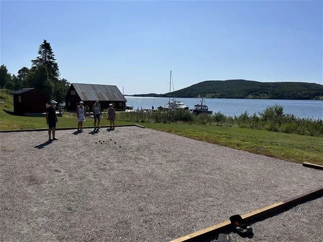 Bild på Skuleberget Havscamping med en vy över en sjö och omgivande skogklädda berg. Perfekt för naturälskare som söker en idyllisk plats för camping och friluftsaktiviteter.