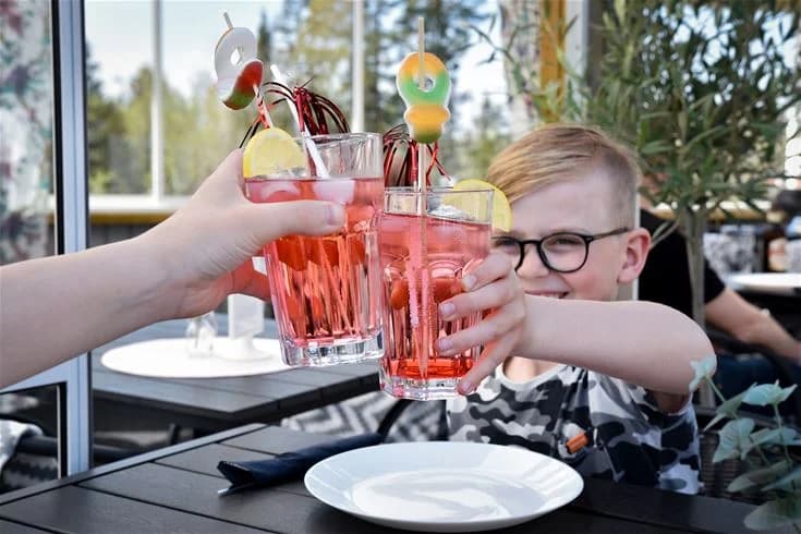 Ett bord dukat med glas och cocktaildrinkar vid Stenrösets Camping i Trollhättan, med olika typer av drinkglas och en klassisk cocktail i förgrunden.