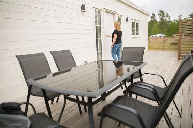 En uteplats med träbord och stolar vid Kinnekulle Camping & Stugby.