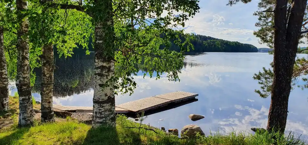 En vacker vy över Granö Beckasin, med blått vatten omringat av träd och grönska i en naturlig miljö.