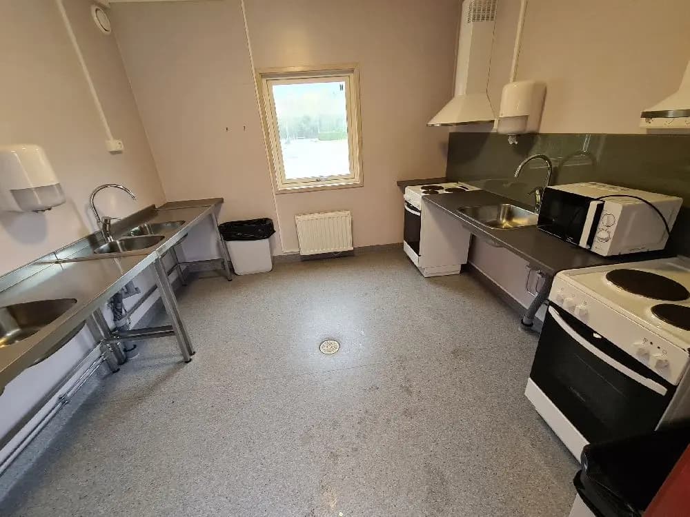 En ljus campingstuga med fullt utrustat kök, inklusive spis, köksbänk och skåp, på Ullared camping.