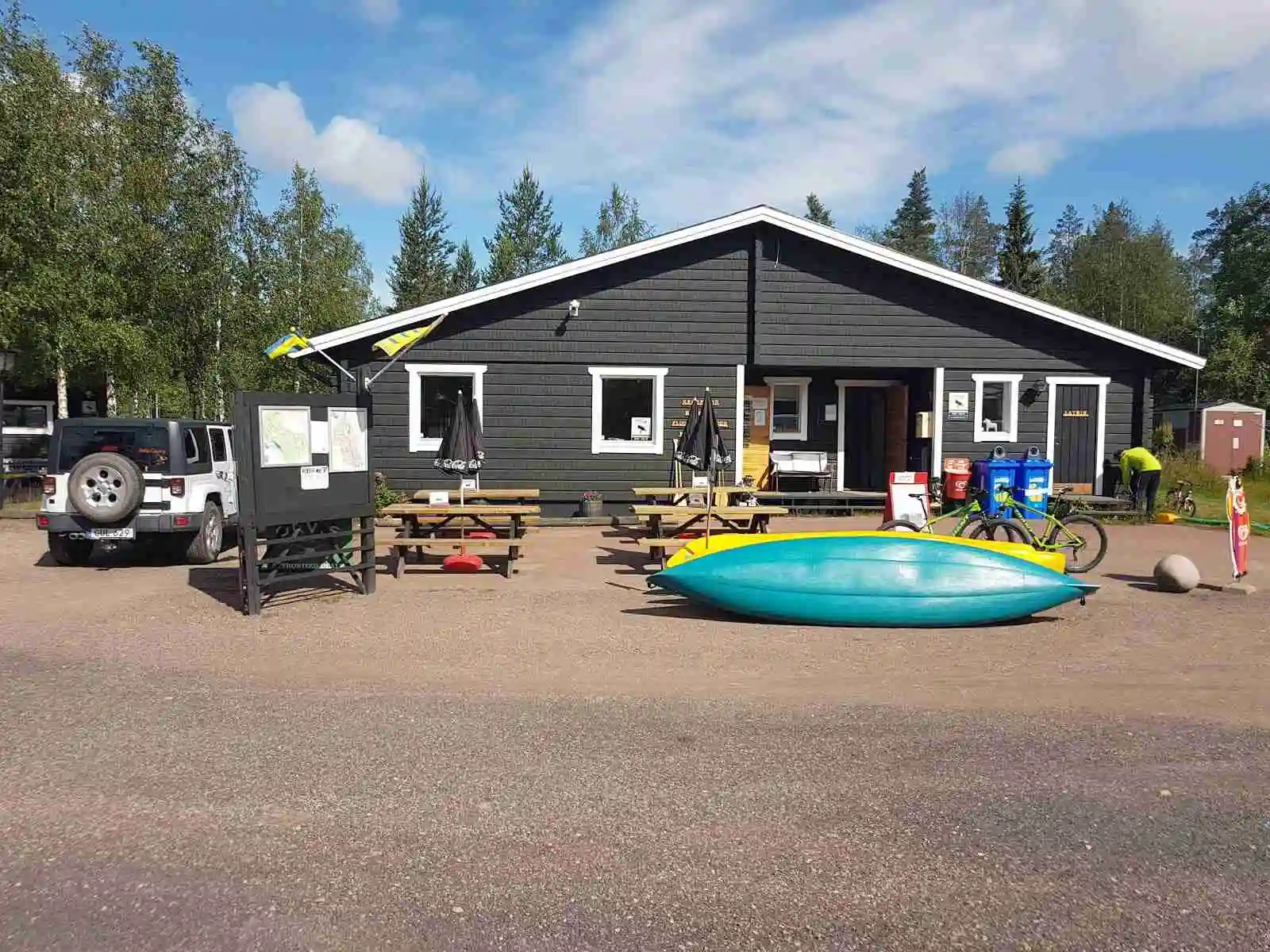 En picknickplats med bord och bänkar i skuggan på Stöten Camping, idealisk för avkoppling och utevistelse.