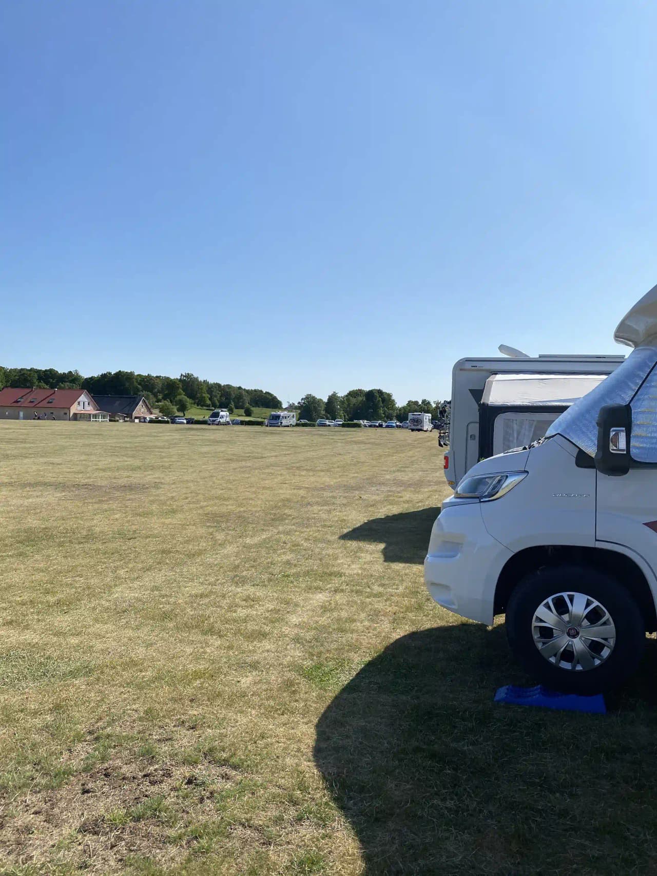 En husbil och en skåpbil parkerade på en gräsyta vid Tönnersjö golfklubb.