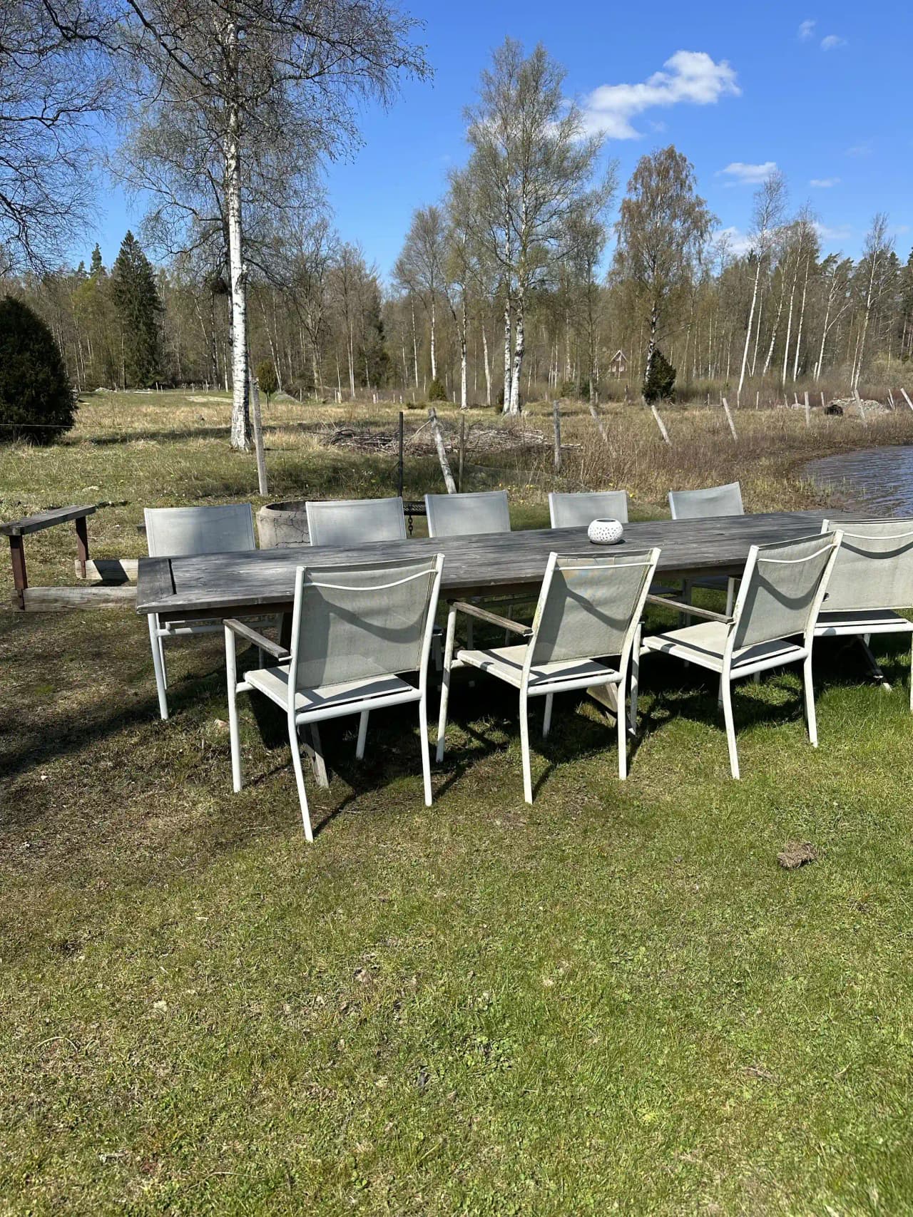 Utomhusmiljö vid Stjernkvist's Hunshult med trämöbler, inklusive stolar, bord och en bänk, placerade på gräsmark.