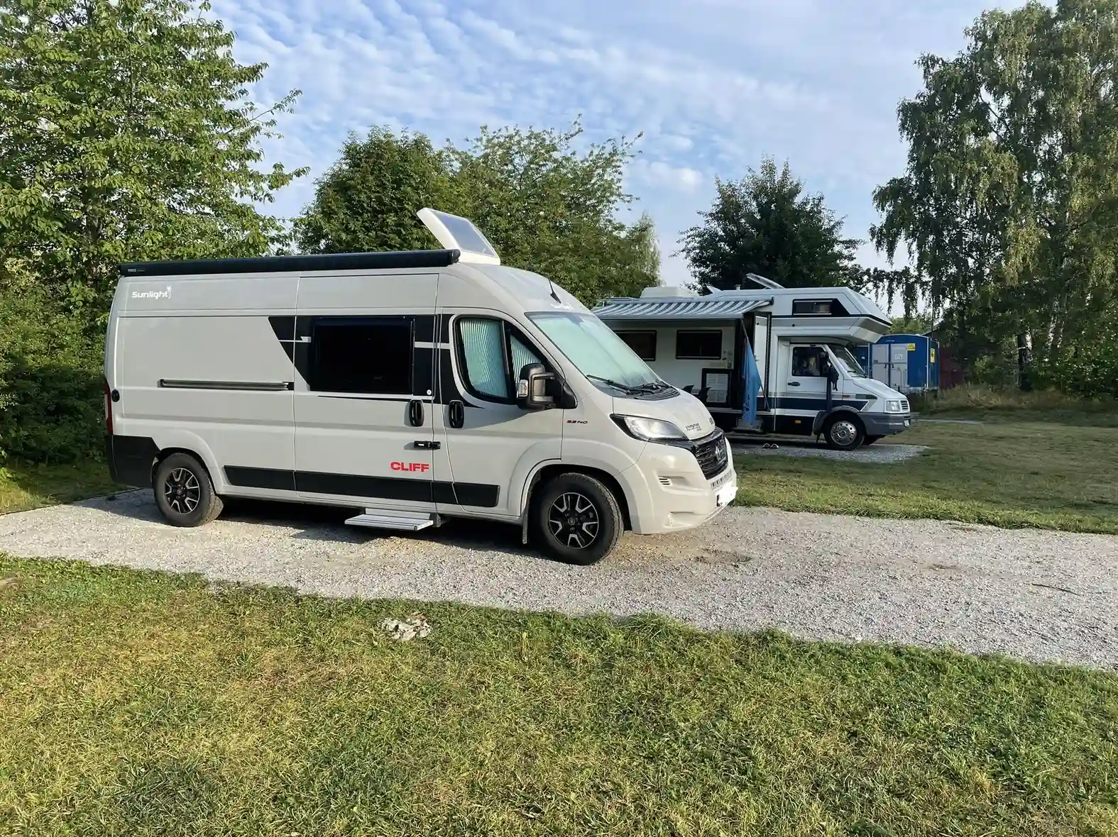 En husbil parkerad på Björknäs camping, omgiven av grönska och friluftsmiljö.