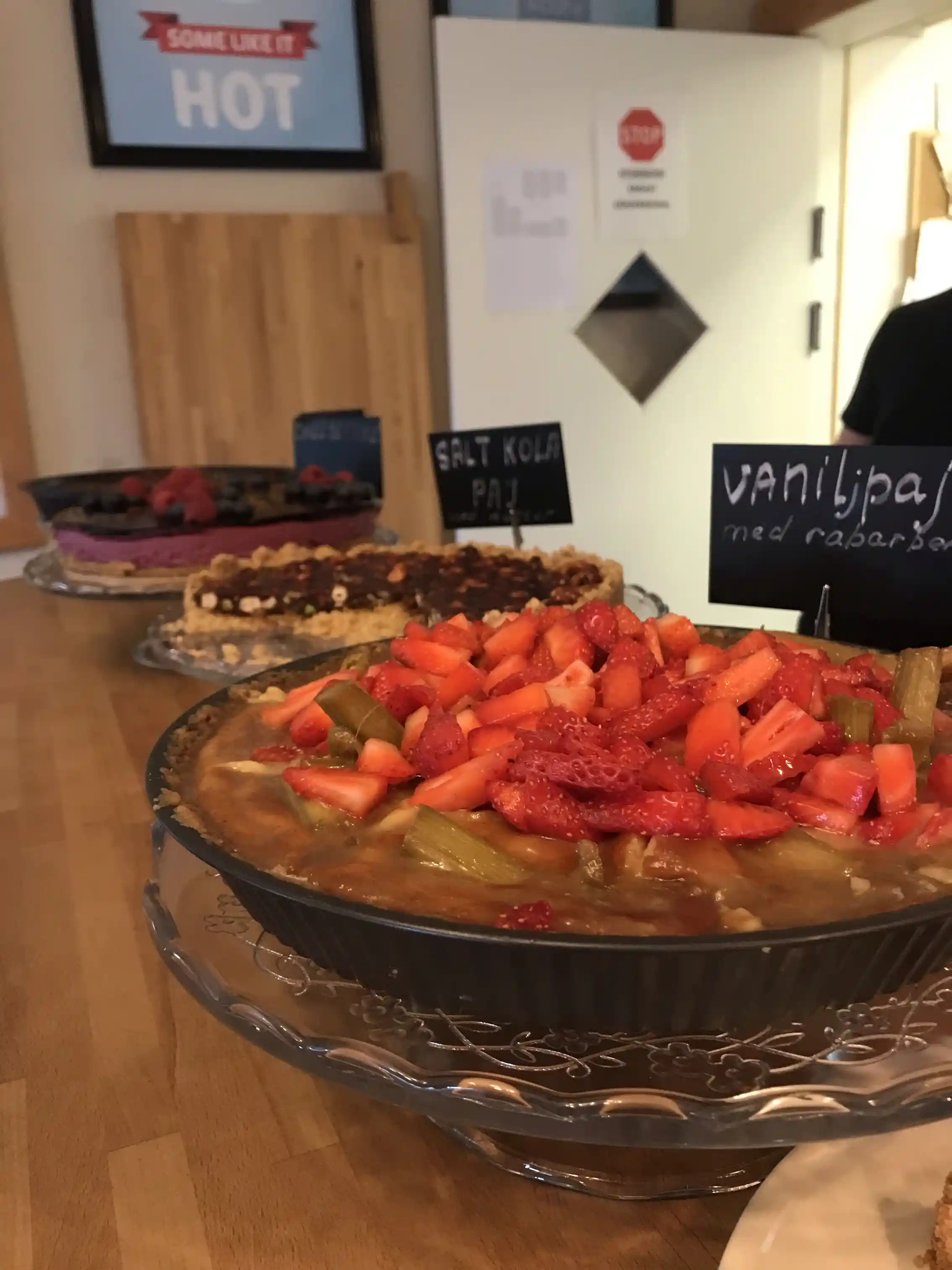 En närbild av olika bakverk och frukt upplagda på tallrikar, arrangerade på ett bord vid Ånge camping.