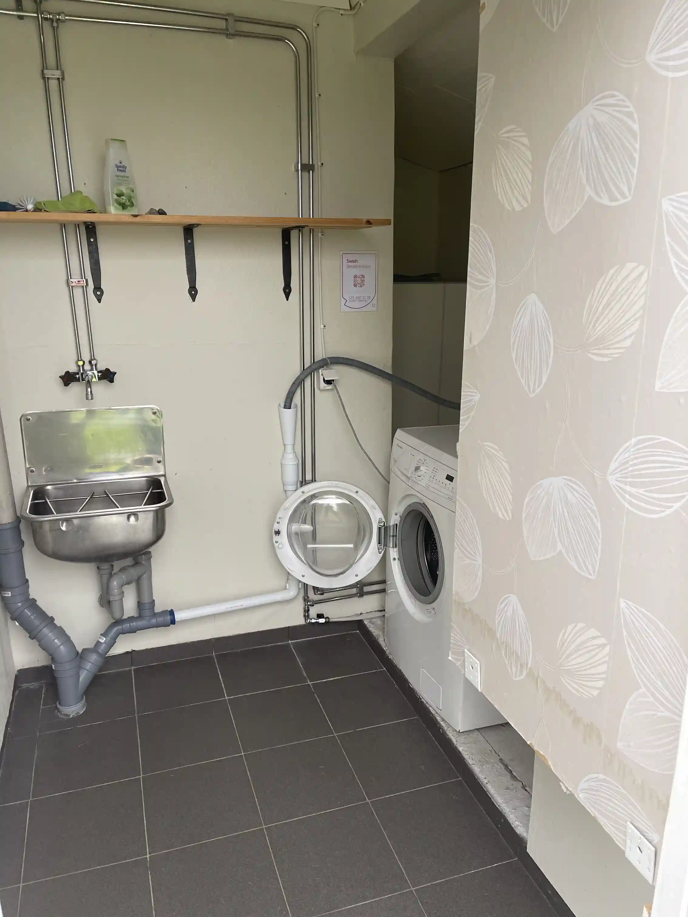 En tvättstuga på Åmsele camping med tvättmaskin och torktumlare, ljusa väggar, kakelgolv och enkel inredning.