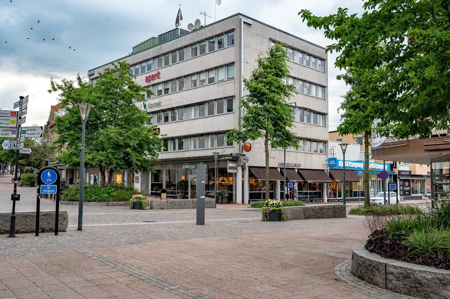 Bild av Värnamo camping som visar en asfalterad väg i ett stadsnära område. Runt omkring ses kommersiella byggnader och ett grannskap med urban design.