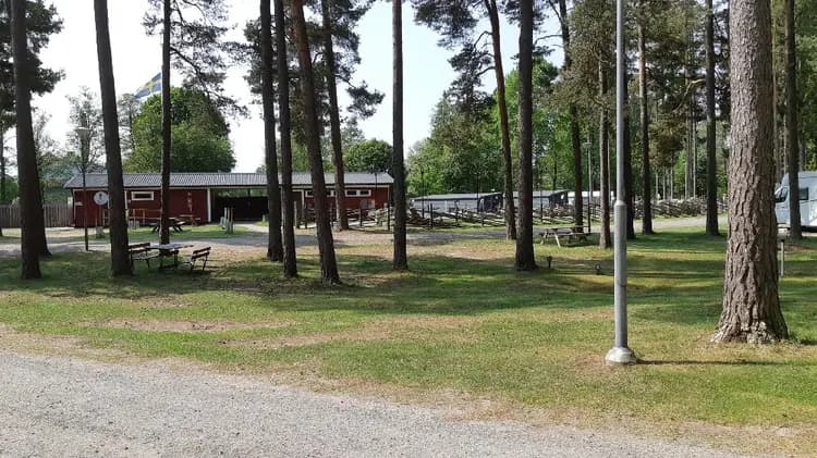 En grön och öppen campingplats i Värnamo med gräsbeklädda områden och träd som ger skugga.