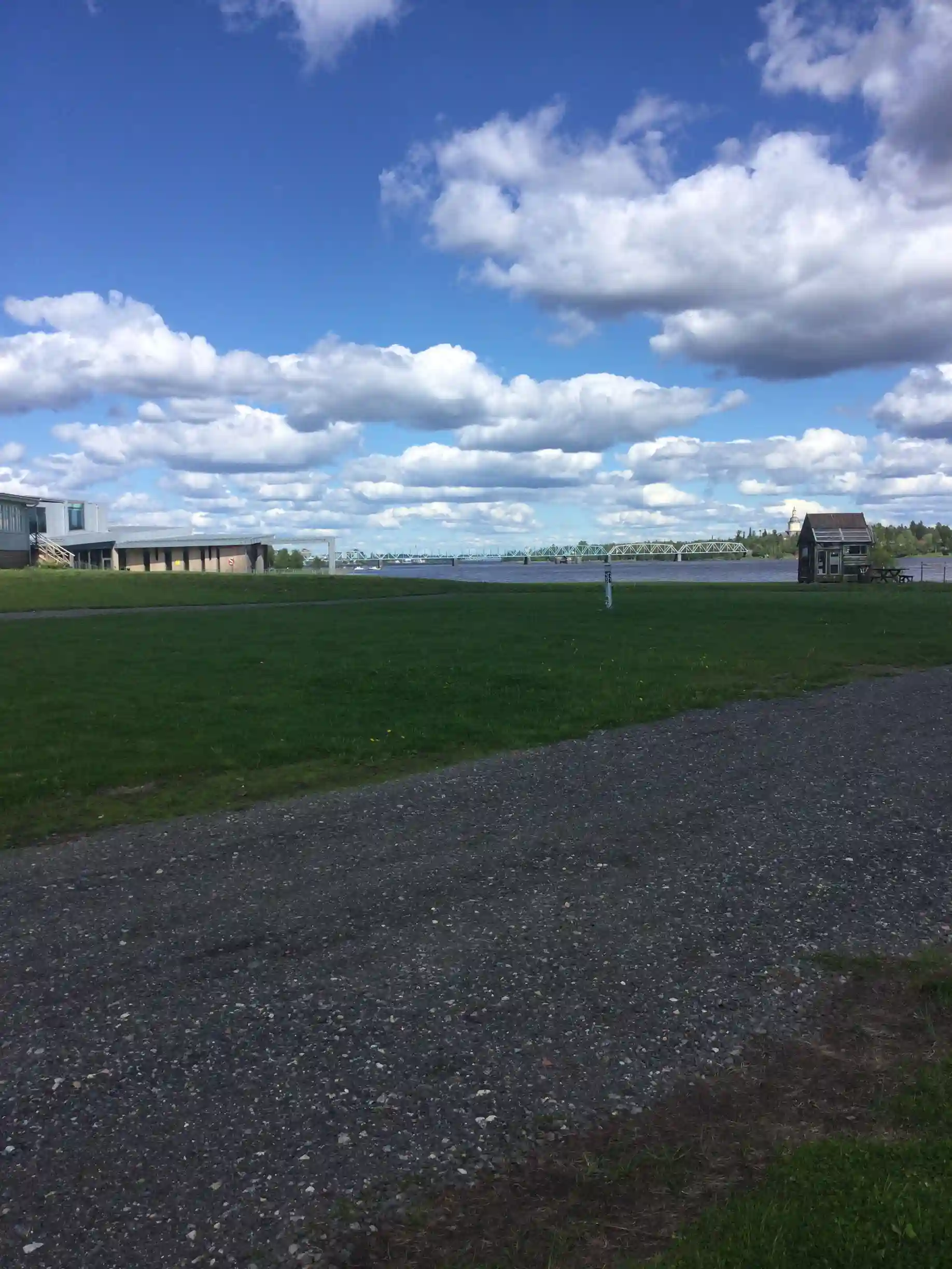 En vidsträckt gräsbevuxen slätt under en klar blå himmel med några moln vid horisonten.