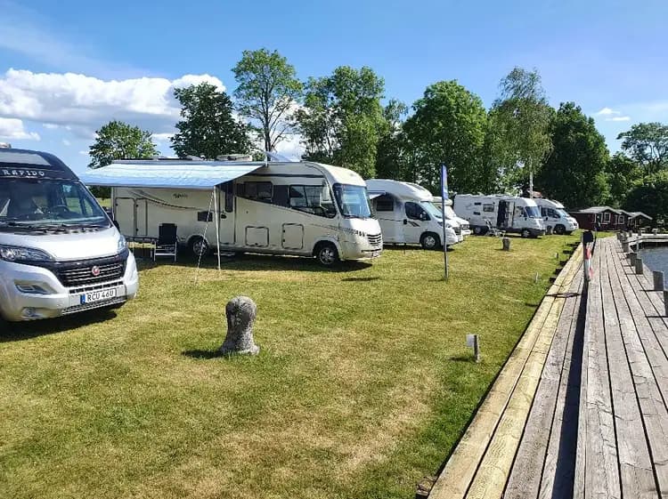 En husbil och en husvagn parkerade på en grönskande campingplats i Jonsboda.