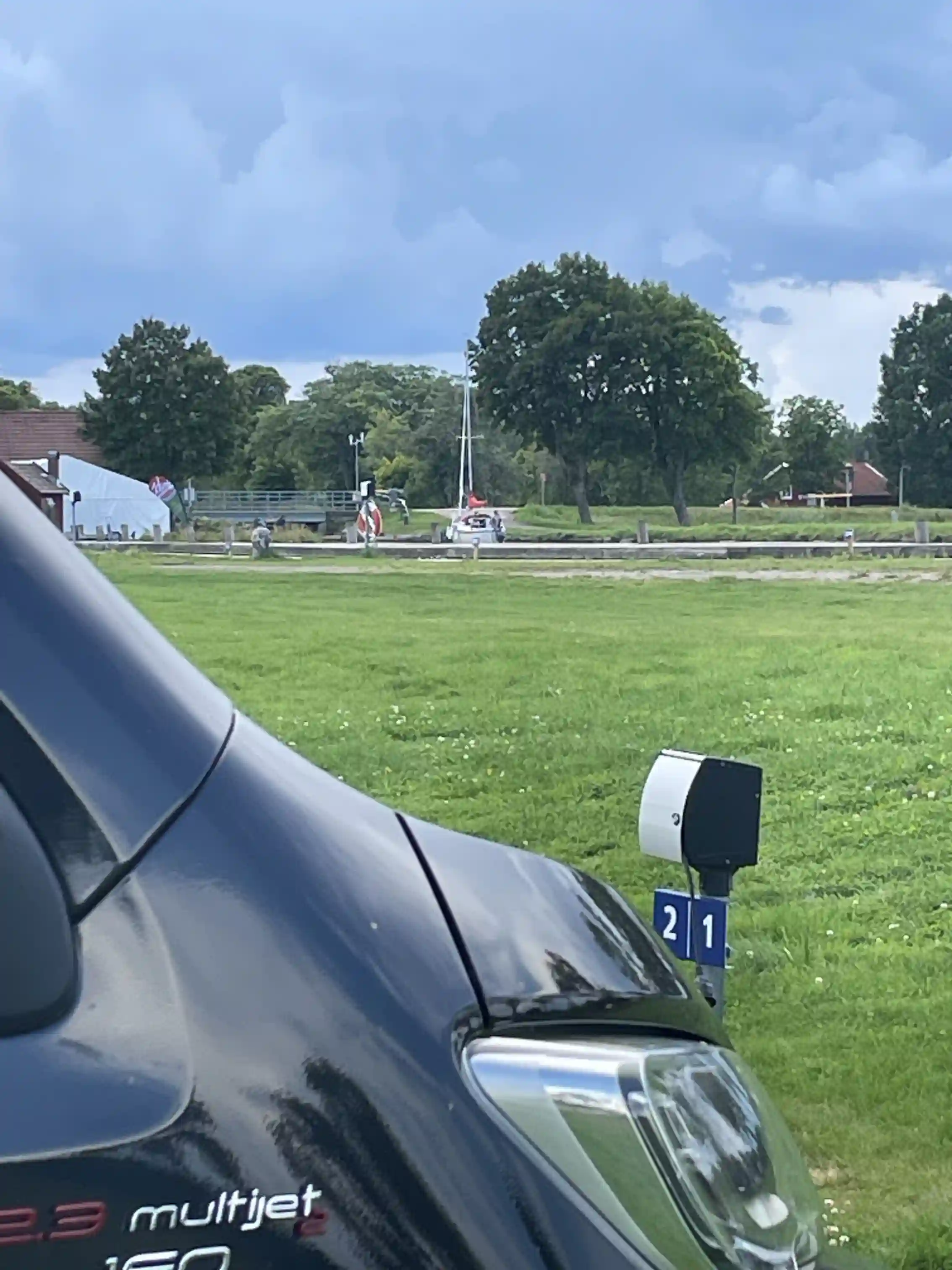 En parkerad bil vid en lugn vägkant i Jonsboda, omgiven av frodig grönska och skog i bakgrunden.