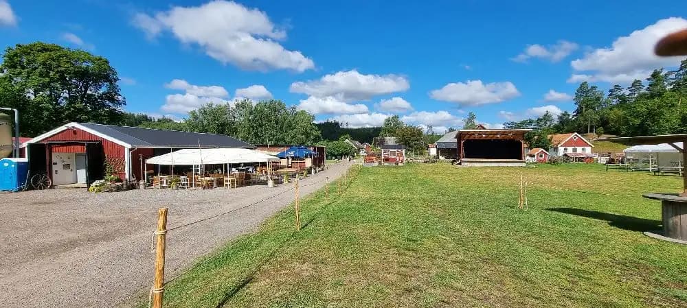 En skuggig gårdsplan på Gunnagård, omgiven av grönska.