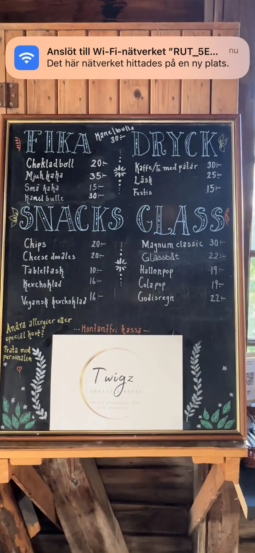 Bild som visar en handskriven meny på en griffeltavla med platsen Trångsvikens bygdegård. Texten är skriven med vit krita och tavlan har en träram med mörk träfinish.
