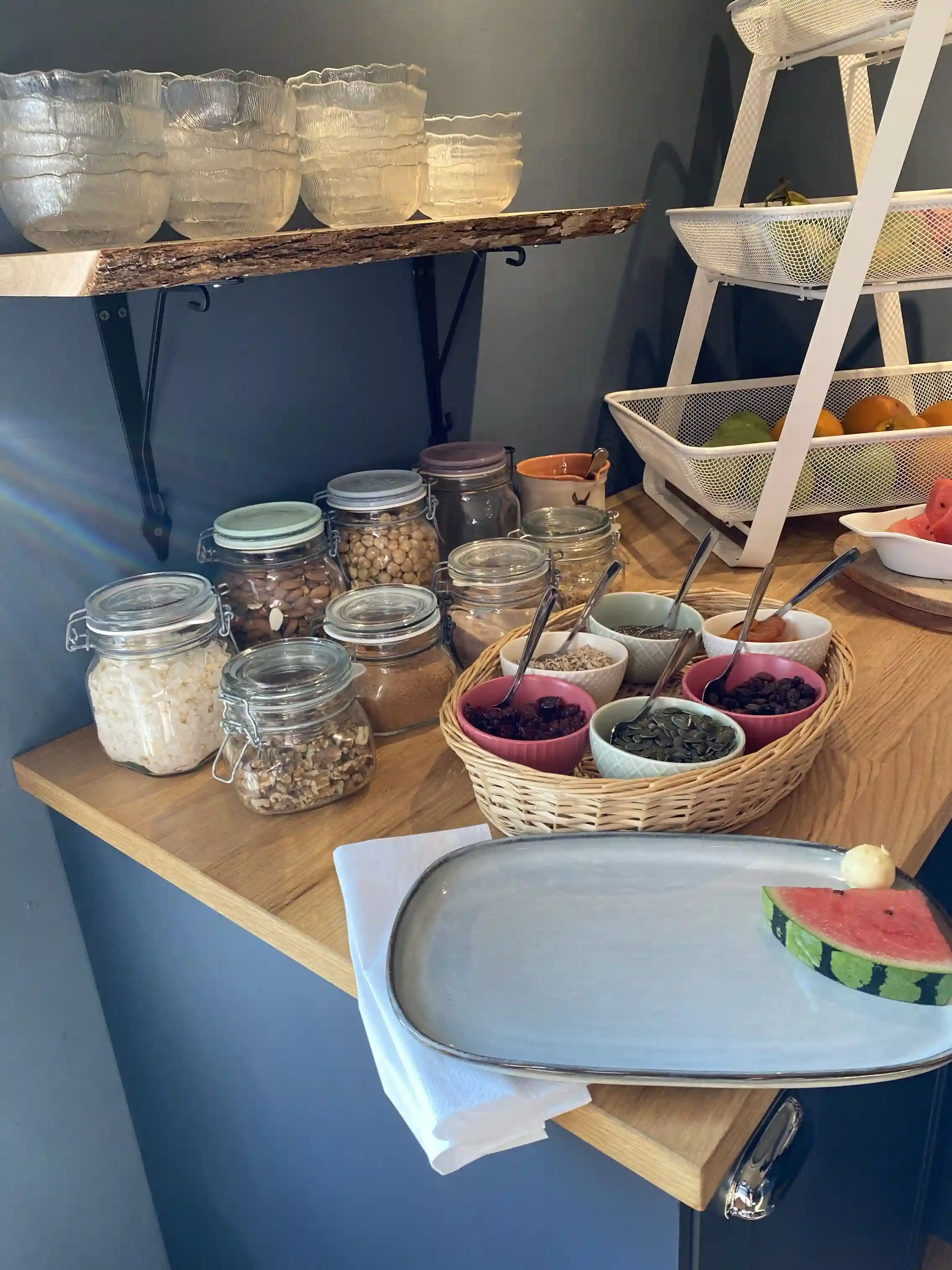 En hylla fylld med olika livsmedel, skålar och förvaringsbehållare.