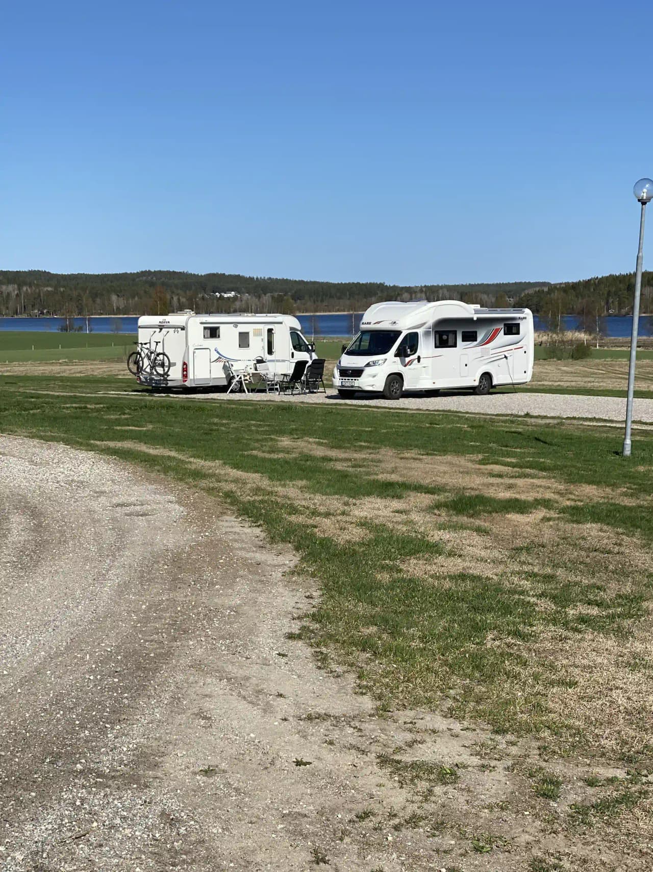 En grupp husbilar och lastbilar parkerade på en grusplan vid Älvsta Lodges.