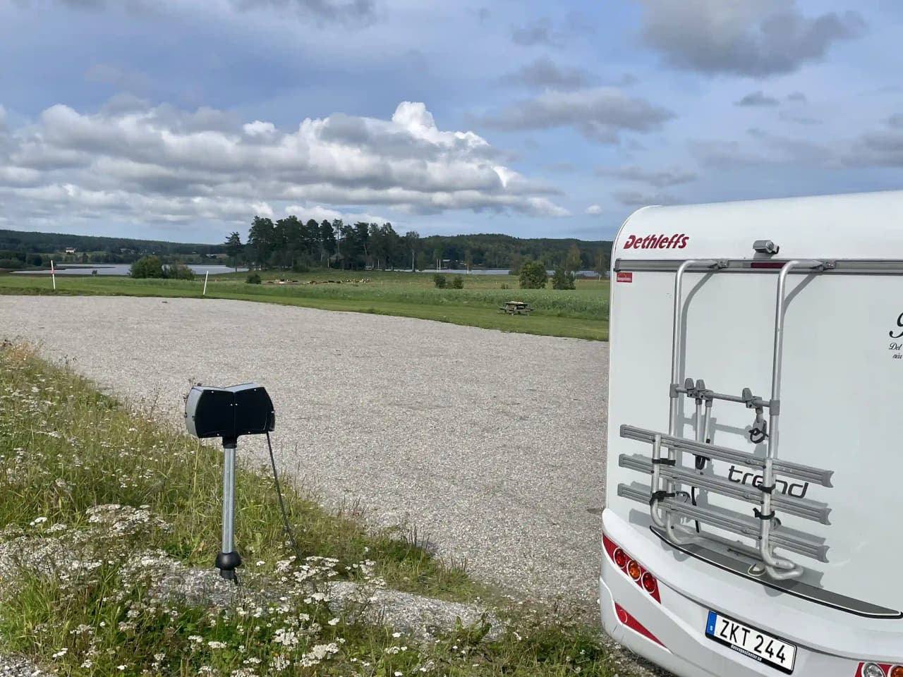 En husbil parkerad vid älvstalodges, omgiven av natur, ses i bild.