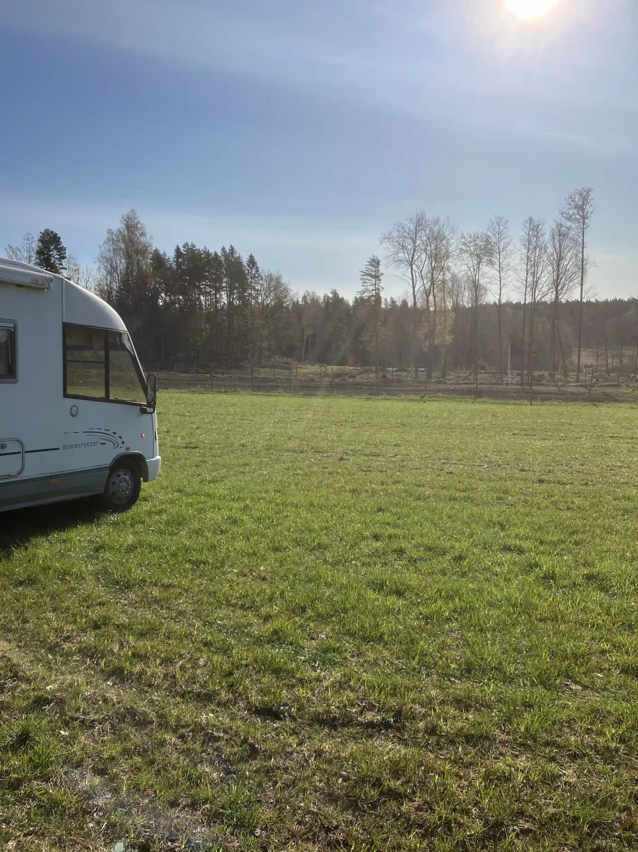 En lummig campingplats med gröna gräsytor, omgiven av landsbygd och ängar.
