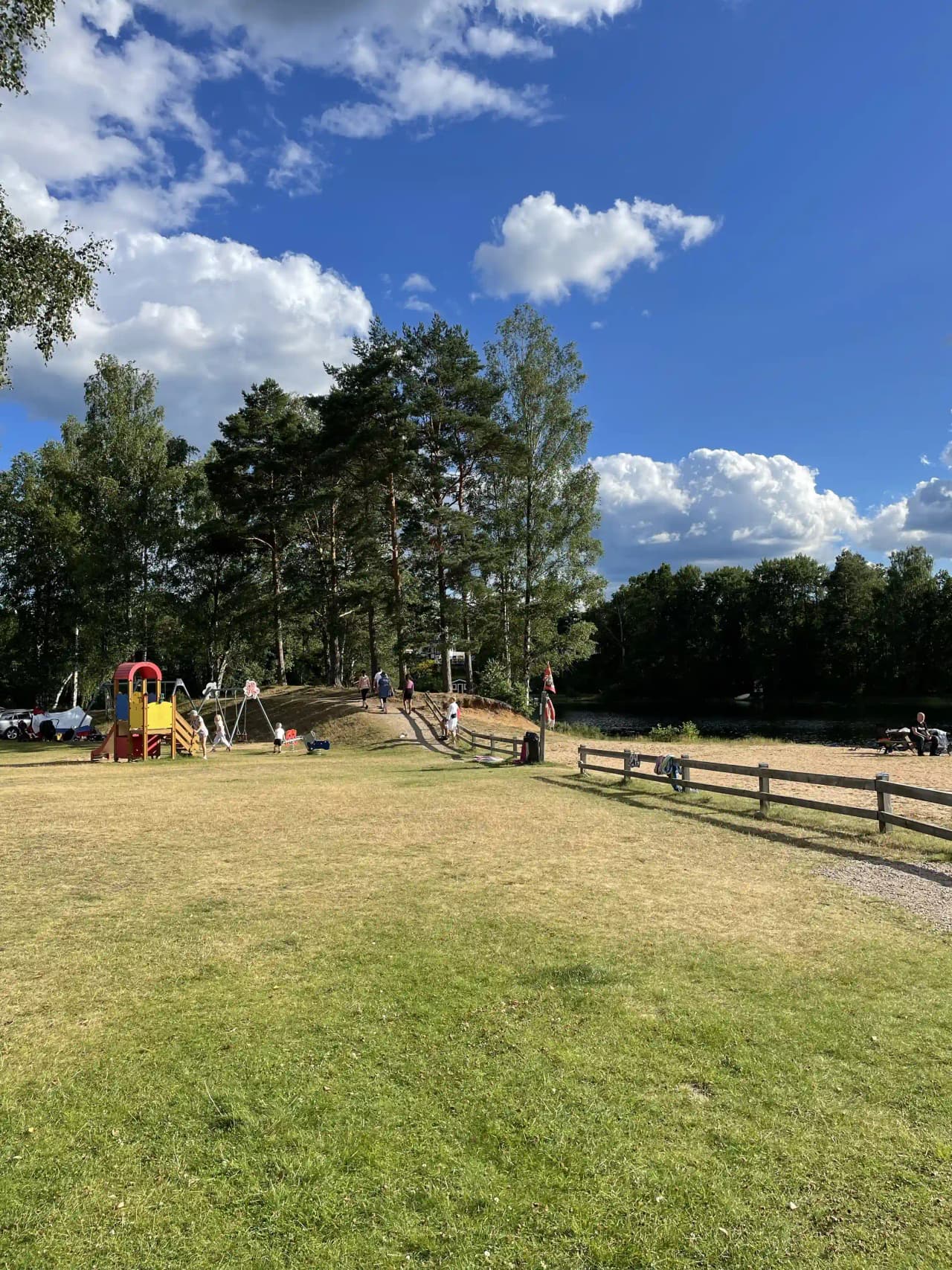 En grönskande campingplats i Överlida med träd, öppna ytor och sommarhimmel. Perfekt för avkoppling och rekreation.