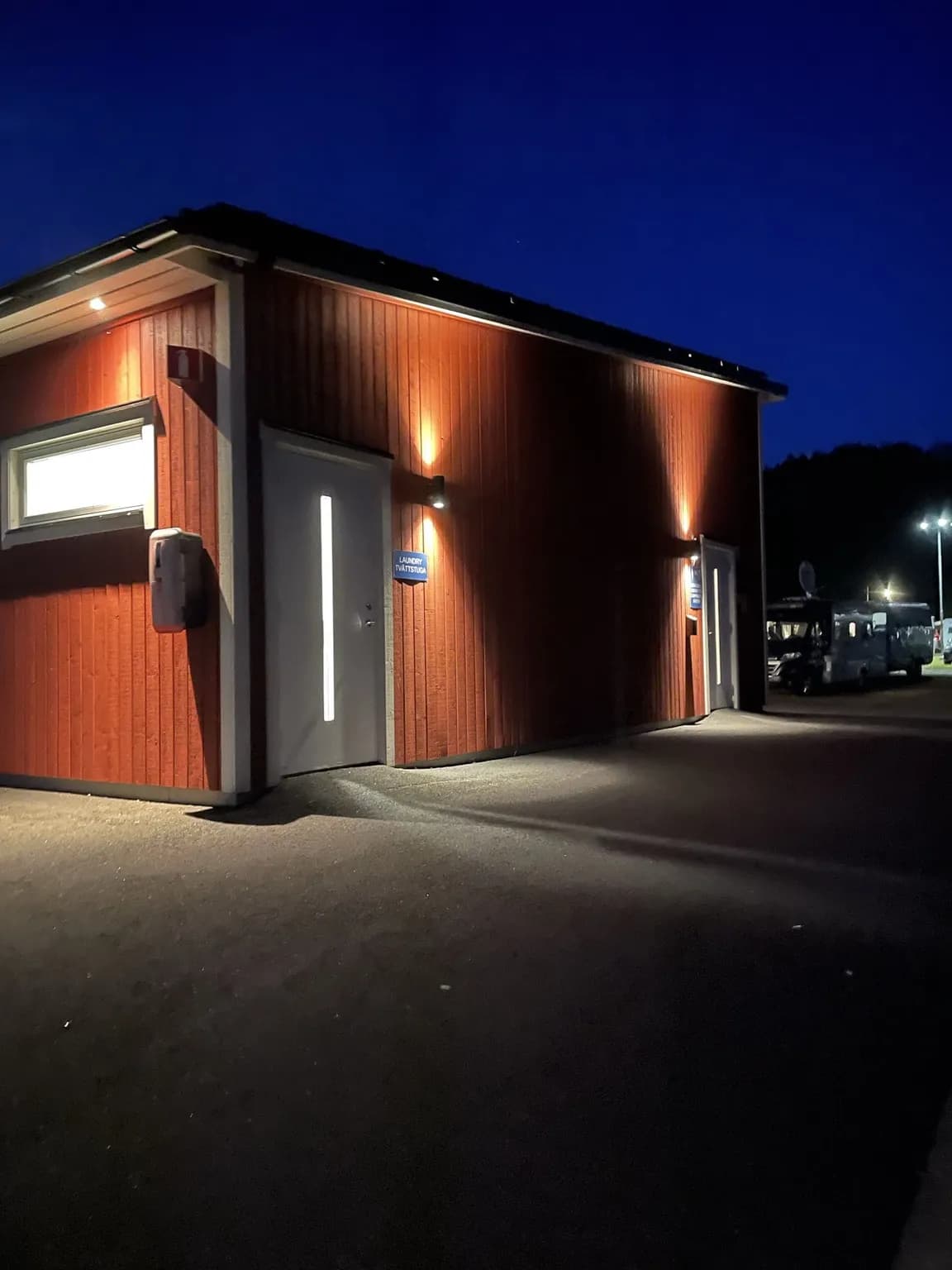 En kvällsbild av Overlida Camping visar en belyst campingplats med säkerhetsbelysning som skapar en trygg atmosfär i mörkret.