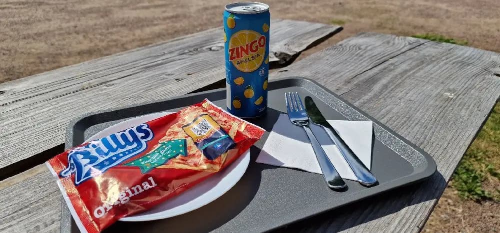 En matlåda med snabbmat, innehållande olika ingredienser som kött och andra tillbehör, syns framför Hamra Stugbys logotyp.