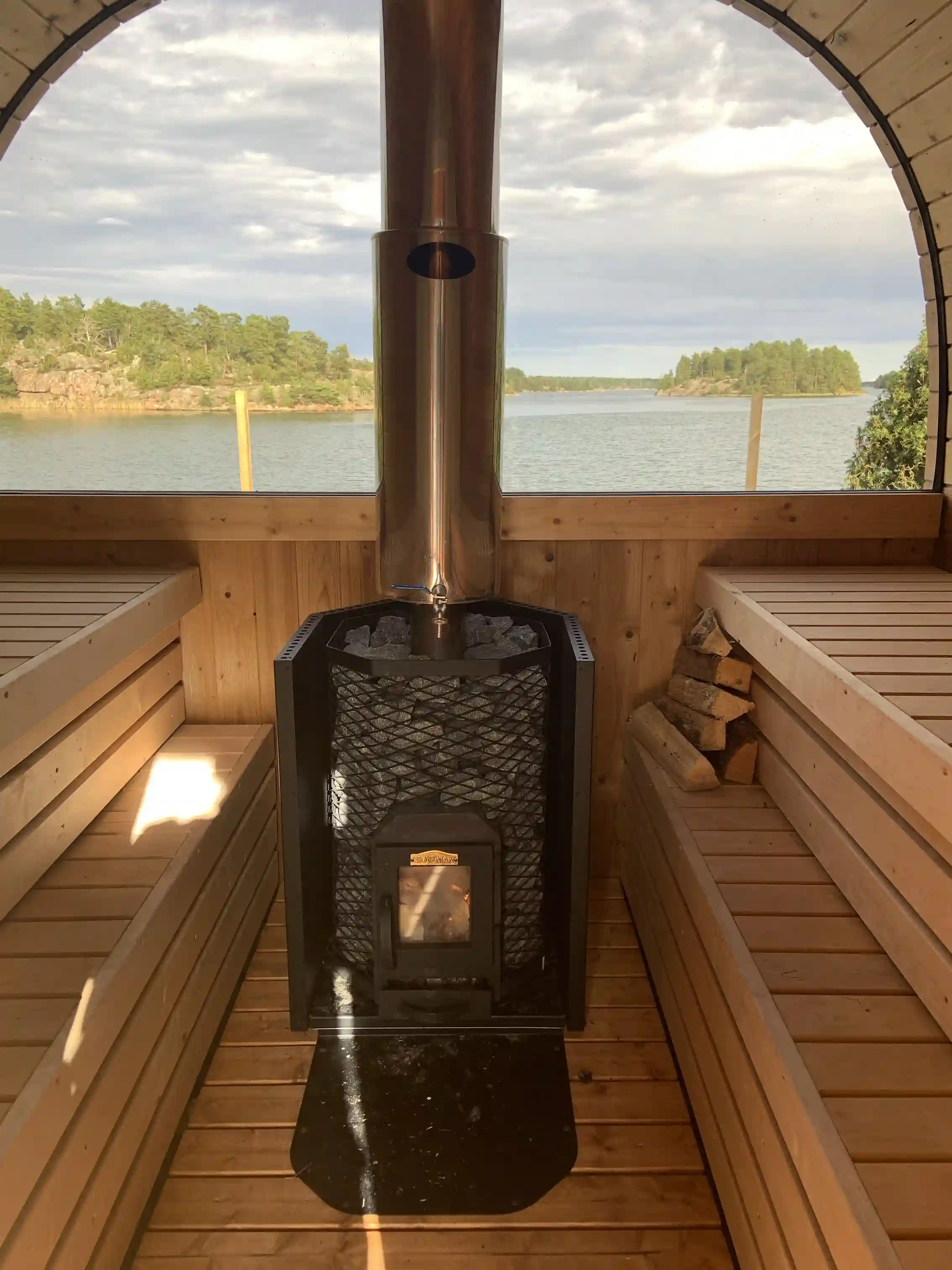 En solig dag vid Eriksviks hamn, där en välpolerad träbrygga av ädelträ sträcker sig ut över det glittrande vattnet.