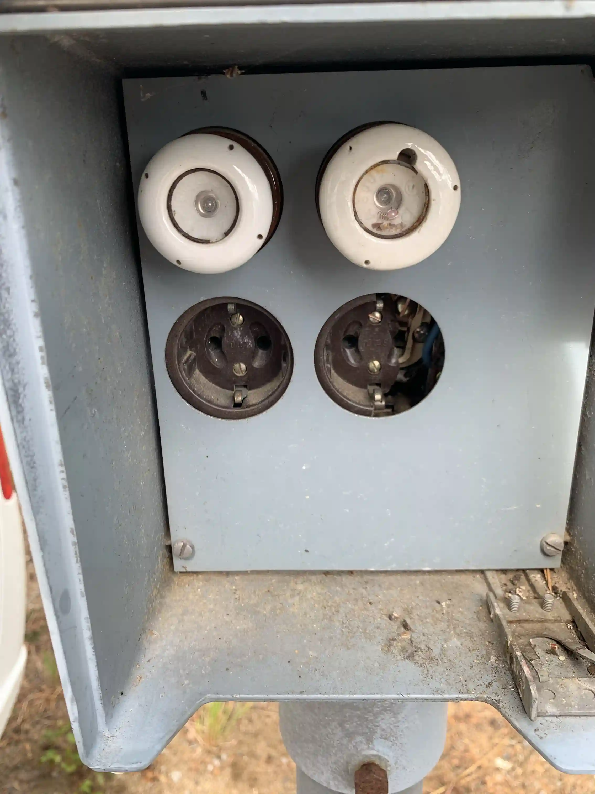 En strand vid Sandnäsets bad & camping med en maskin placerad nära vattnet, omgiven av grönska och semesterfirande besökare i bakgrunden.