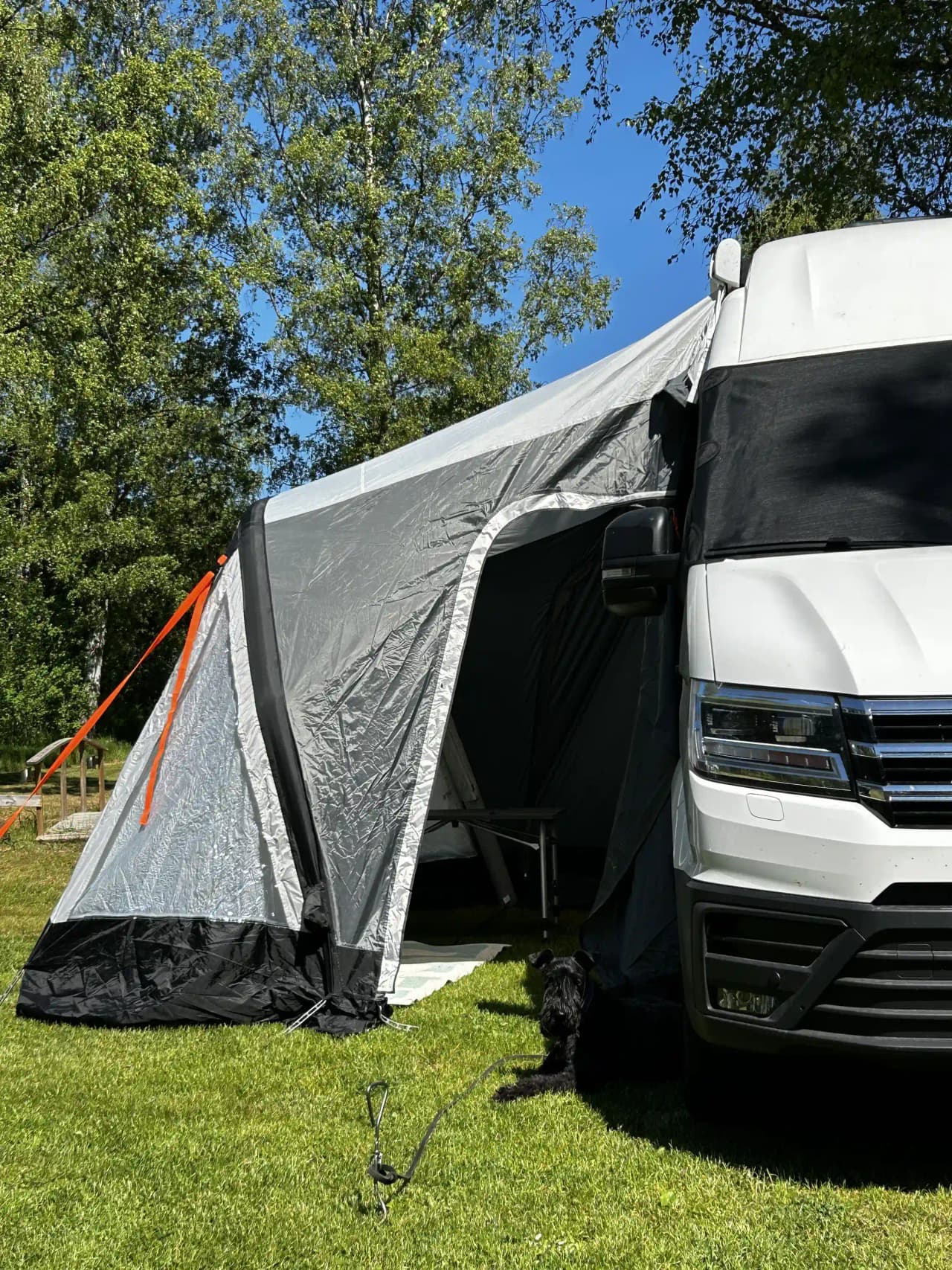 En minivan från Volkswagen parkad vid Kaffetorpets camping med tältduk i bakgrunden.