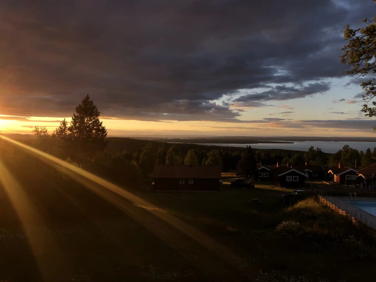 En solnedgång över landskapet vid Åsengården, med en färgglad himmel och mjuka molnformationer som speglar kvällsljuset.