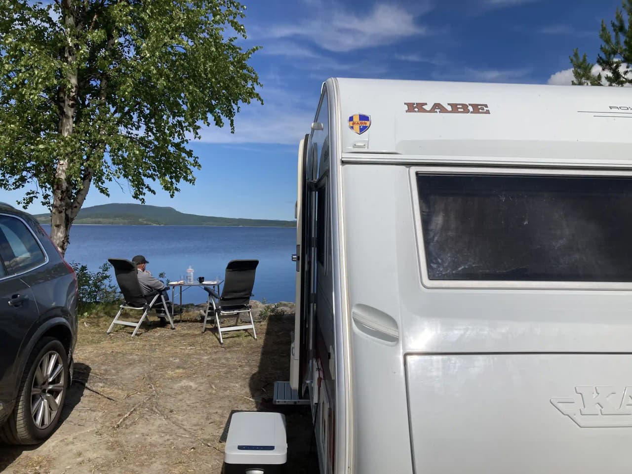 En campingplats med flera husbilar och husvagnar parkerade i en naturskön miljö vid Gäddede Camping & Stugby.