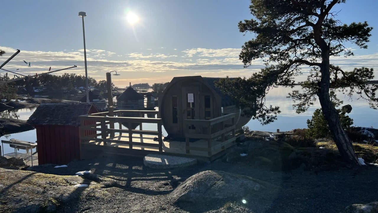 En vintrig scen vid Filsbäcks camping med en liten stuga omgiven av snötäckt landskap.