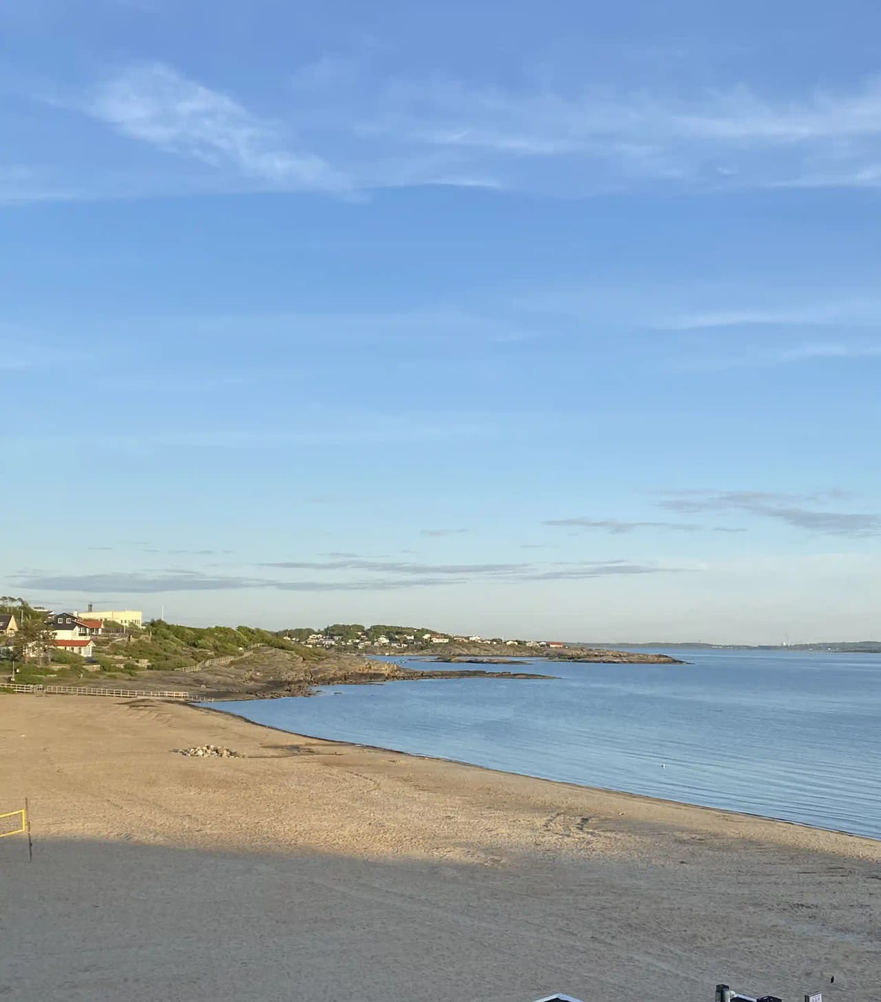 Vy över en strand med klarblå himmel och hav, sandstrand i förgrunden och horisontlinje i bakgrunden vid Åsa Camping & Havsbad.
