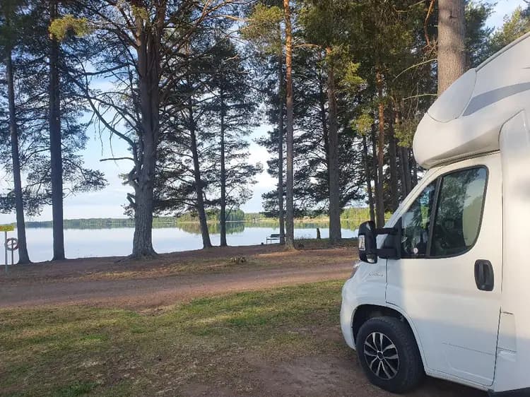 Bilden visar parkerade bilar, inklusive husbilar, på Våmåbadets campingområde.