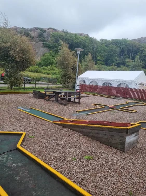 En lekplats i en park vid Rörviks camping med lekutrustning för barn i en offentlig miljö.