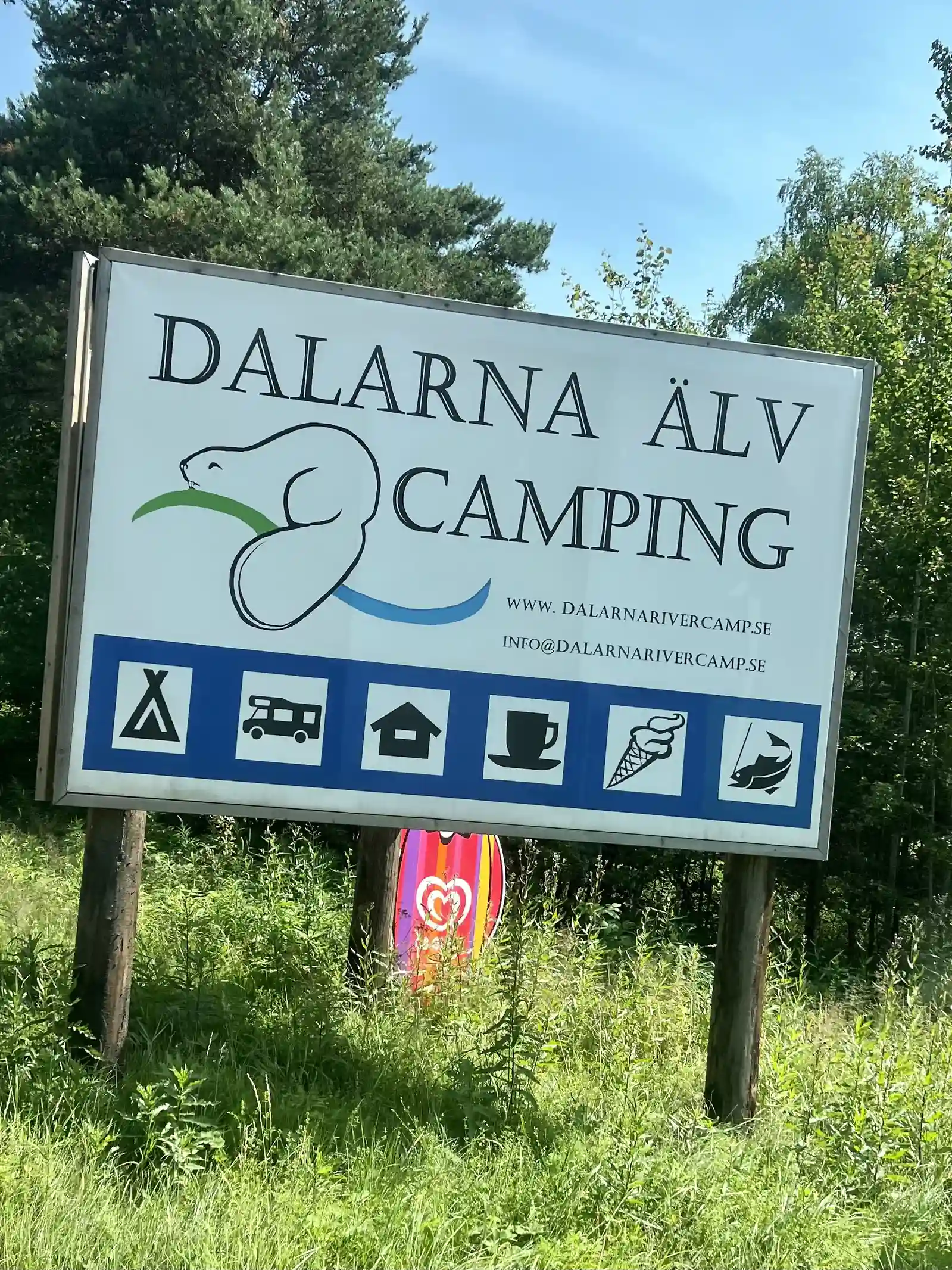 En campingplats vid Grebbestadfjorden med tält och husvagnar i en naturskön miljö, idealisk för fritid och semester.