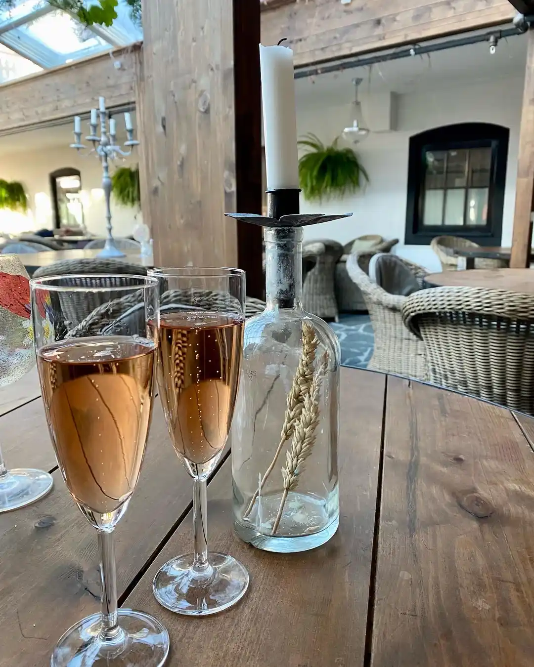 Bilden visar en elegant dukning på Lögnäs Gård, med glas och flaskor med alkoholhaltiga drycker på ett bord, redo för servering i en inbjudande miljö.