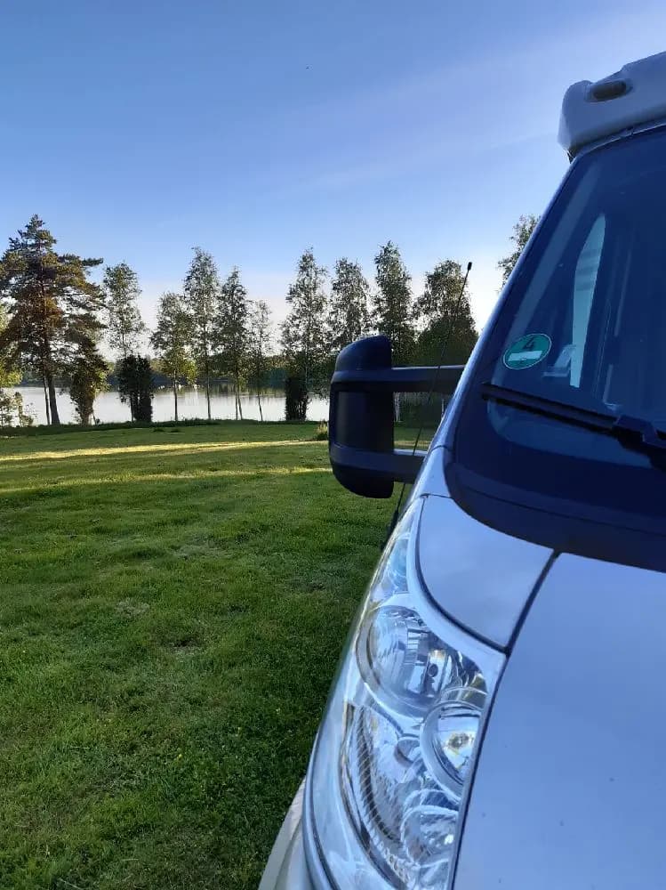 En parkerad skåpbil med fokus på speglar och dörrar, utanför Moarps B&B.