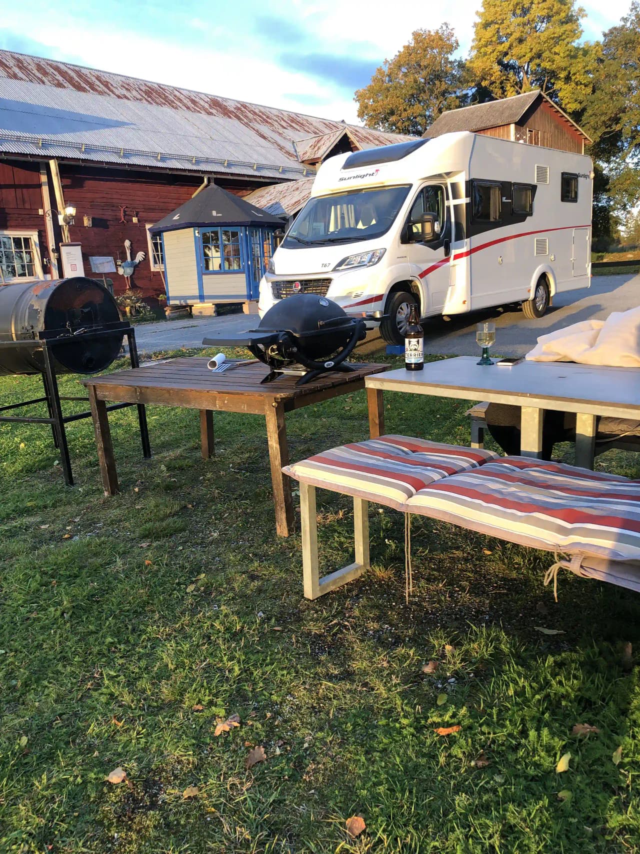 En campingplats på Gustavsvik Resort med uppställda husvagnar och husbilar. Utomhusmöbler, inklusive stolar och bord, är placerade på den gröna gräsmattan.