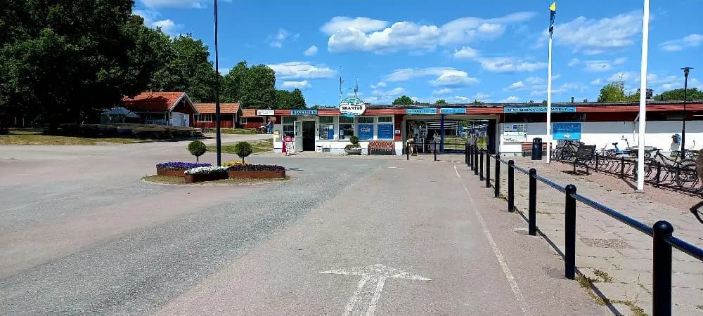 En samling cyklar parkerade på Skantzö Bad & Camping, belägna vid ett offentligt område med flera cyklar och cykeldelar synliga som däck, fälgar och styren.