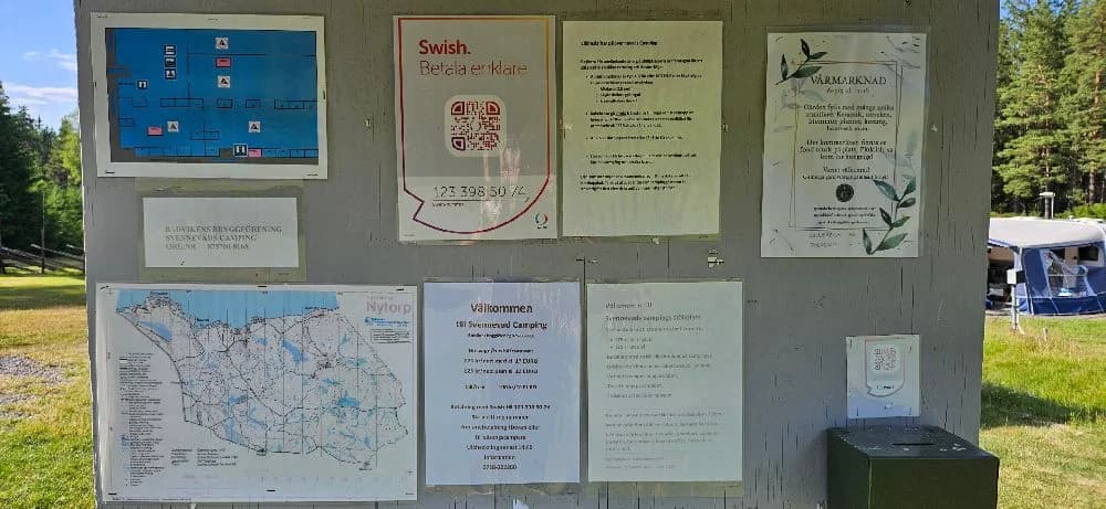 En grönskande skogsstig omgiven av parkmark och växtlighet på Svennevads camping.