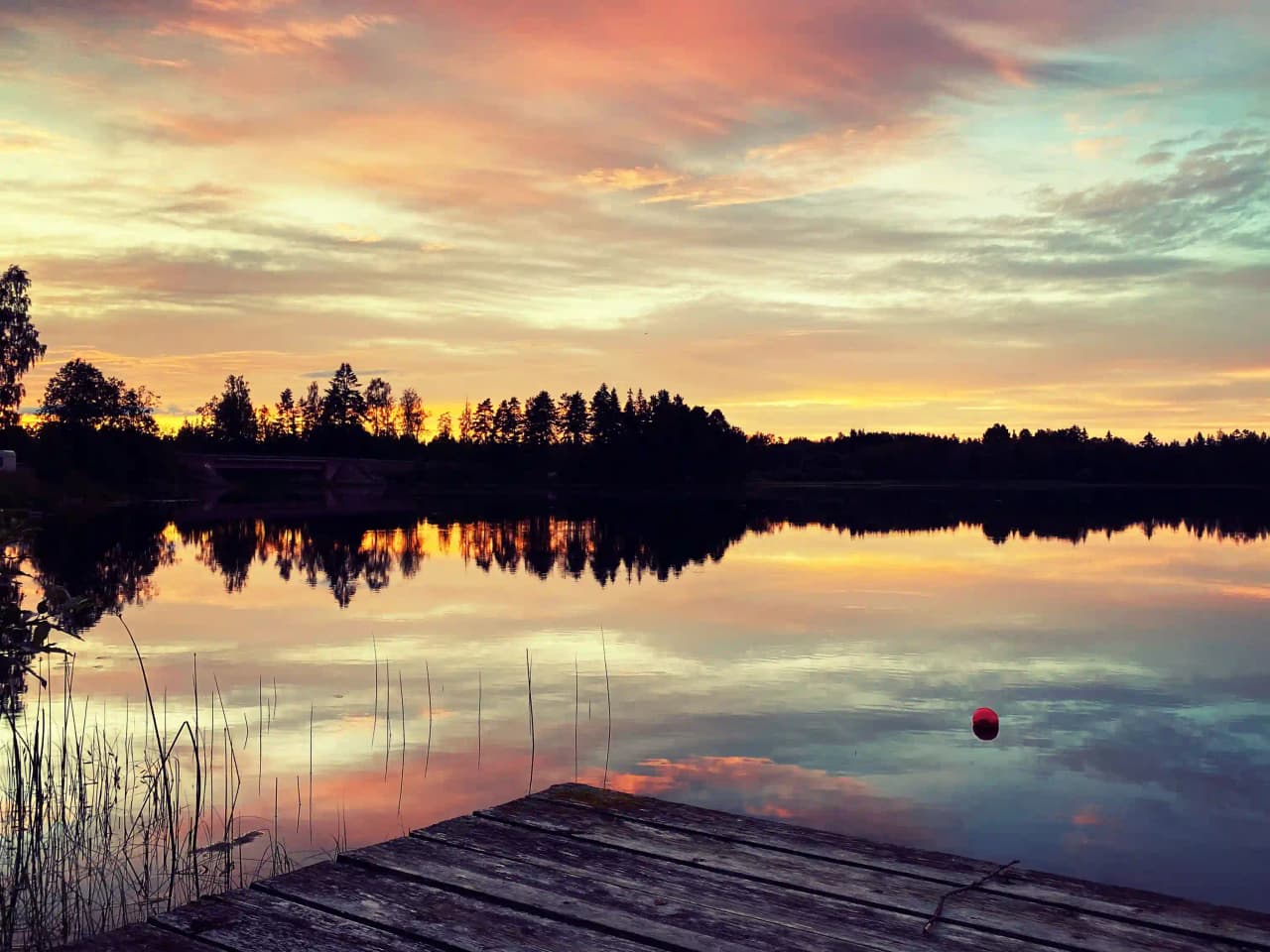 En naturskön vy över en vattenhorisont vid solnedgången, med himlen i blå och orange toner. Perfekt besöksmål för avkoppling vid storslagen natur.
