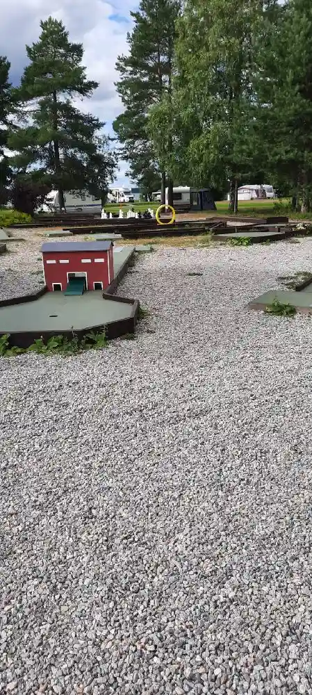 En grusig infart med småsten vid Borgaruddens havsbad och familjecamping, omgiven av natur.