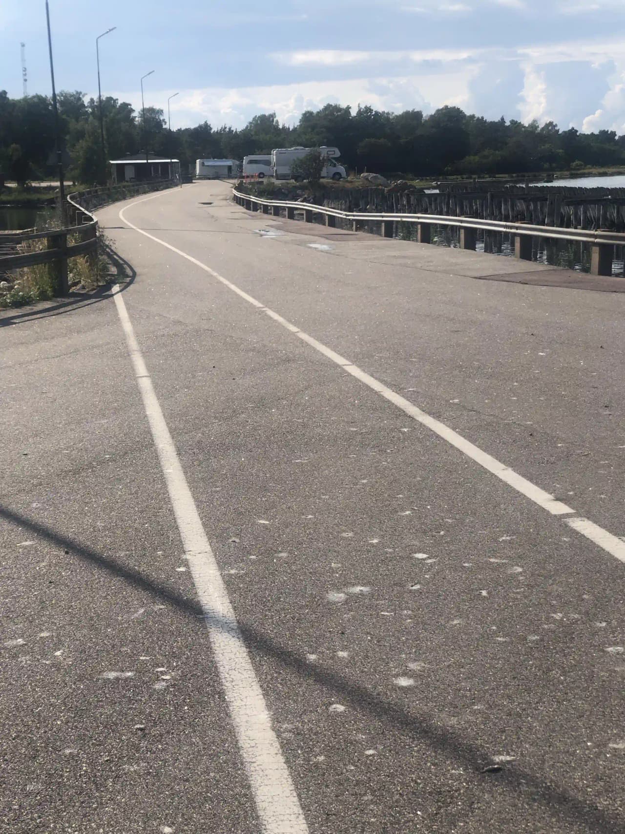 Vy över Böda hamns camping med asfalterade vägar och campingområden. I bakgrunden syns en motorvägsbro i närheten.