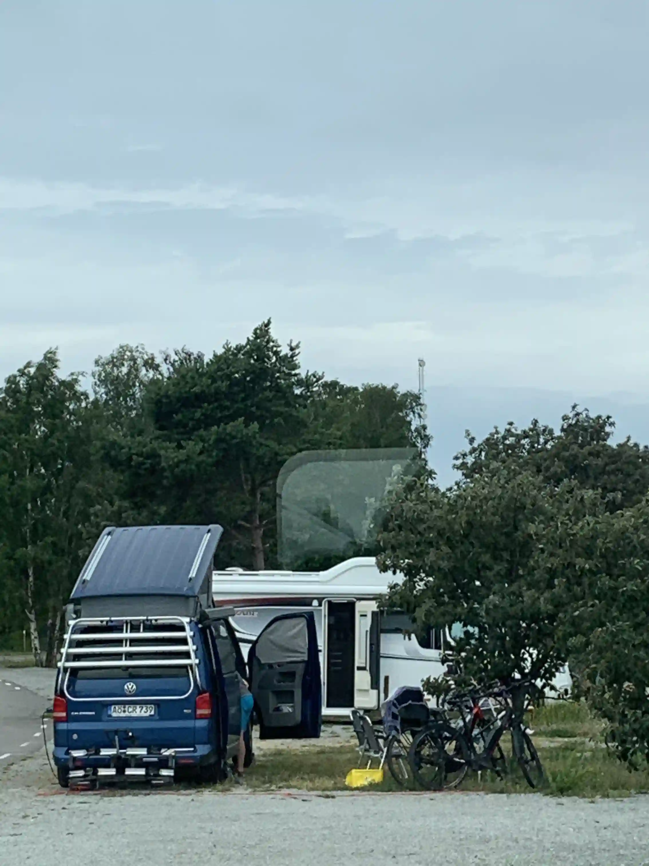 En bild av en bil parkerad på Böda Hamns Camping, omgiven av grönska och typiska campingfaciliteter.