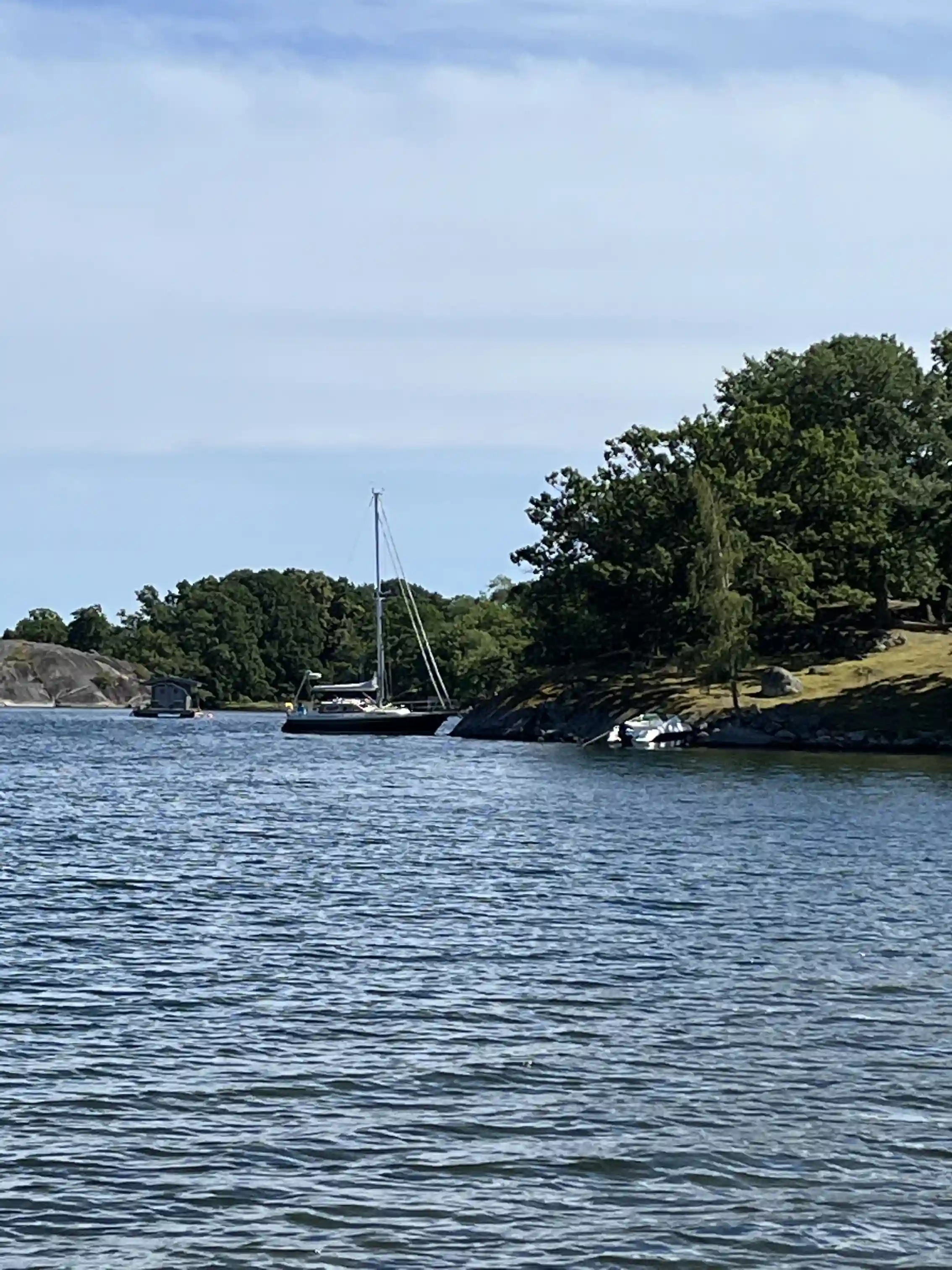 En bild av Järnaviks camping som visar en rofylld vattenmiljö med båtar förtöjda vid en strandkant.