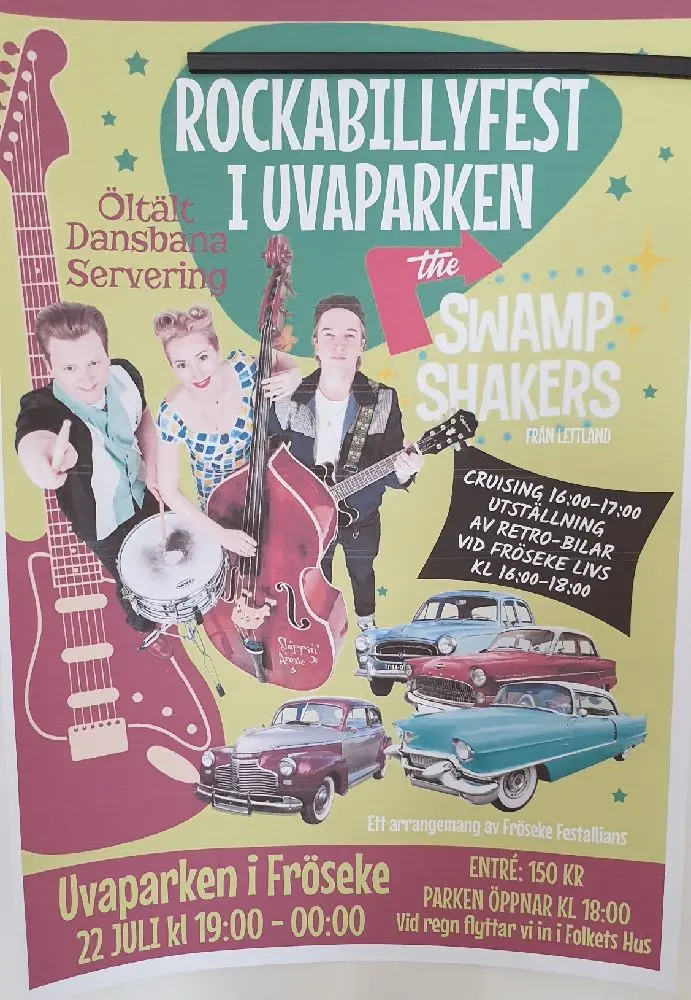 En gitarrist spelar på en akustisk gitarr vid en ställplats i Uvaparken. I bakgrunden syns affischer som gör reklam för musikunderhållning.