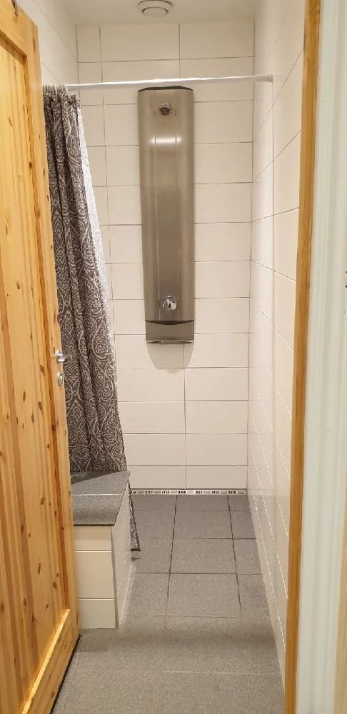 En interiörbild av en stuga på Långsjön Stugor & Camping med trägolv och träpaneler, vilket ger en rustik och naturlig känsla. Platsen ser inbjudande ut för besökare som söker en naturnära upplevelse.