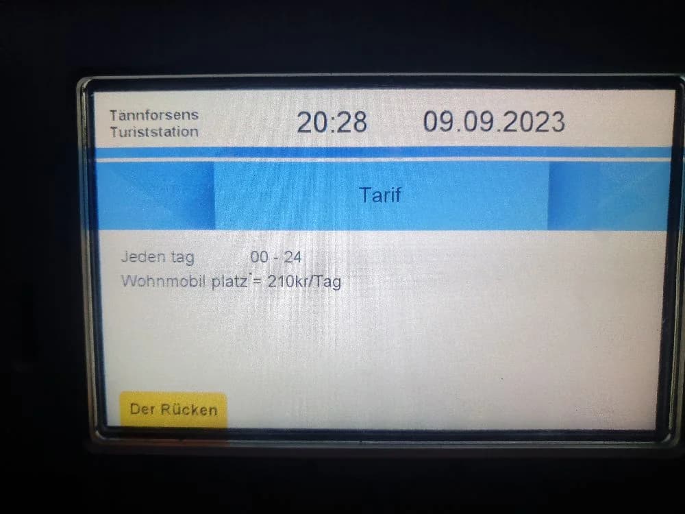 En digital informationsskärm vid Tännforsens turiststation visar besökarinformation och kontaktuppgifter. Skärmen domineras av blåa färger och innehåller olika elektroniska symboler och siffror.